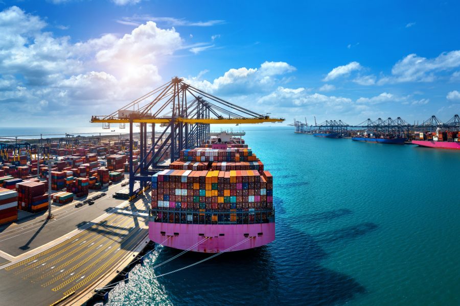 Aerial view of cargo ship and cargo container in harbor.